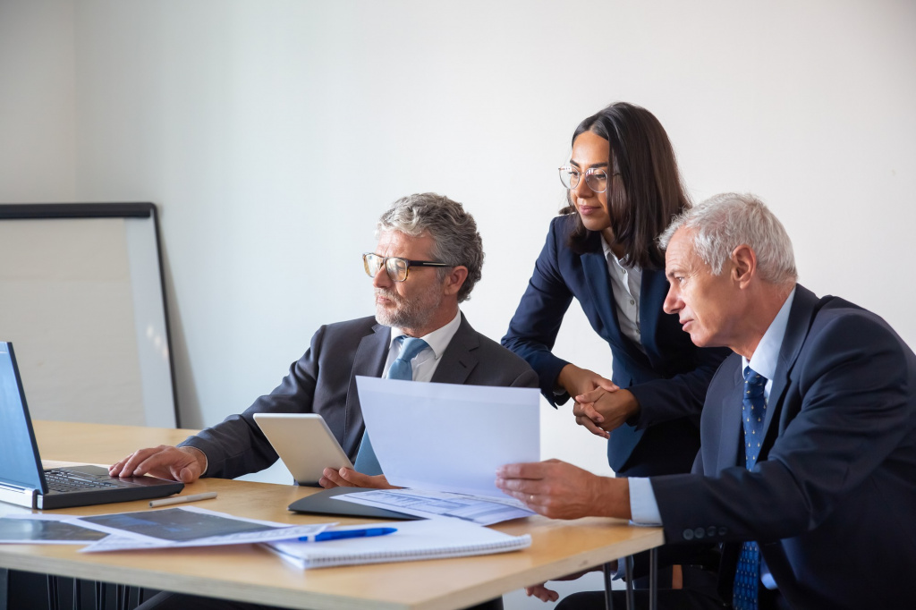 concentrated-partners-using-laptop-working-with-documents-confident-serious-businesspeople-office-suits-discussing-company-project-together-management-business-partnership-concept.jpg